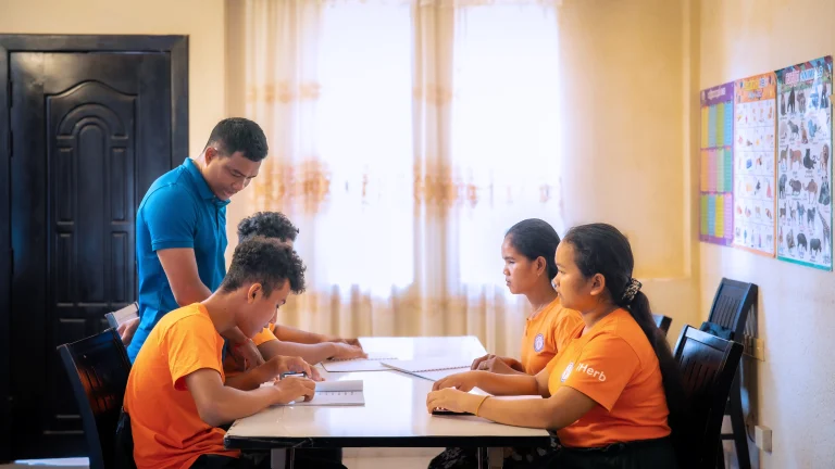 Students practicing English communication skills with a teacher at DYP Learning Center in Cambodia
