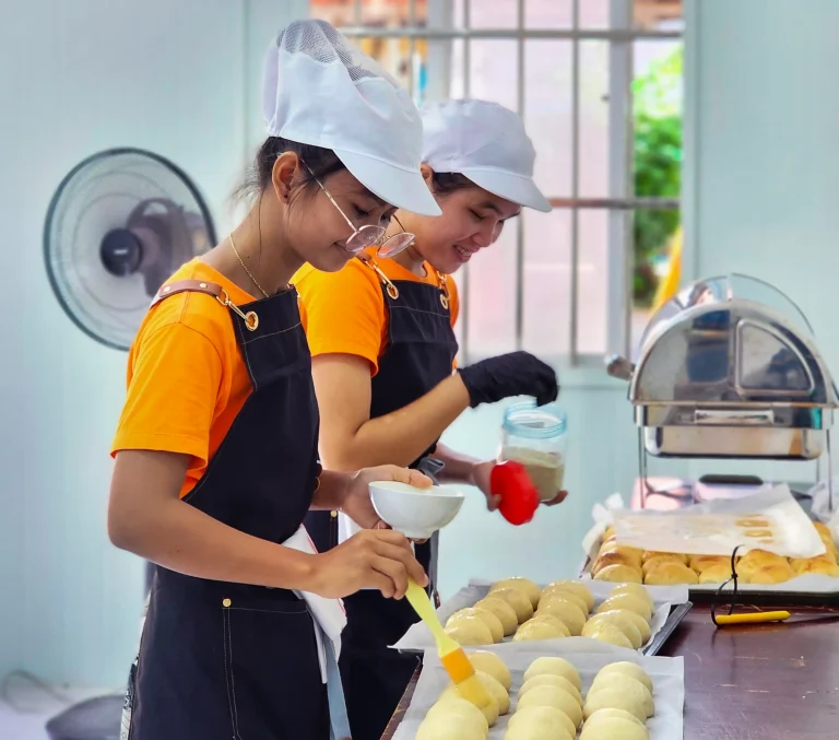 Learners preparing bread and soft rolls using hygienic food handling practices at the DYP Inclusive Café and Bakery in Cambodia