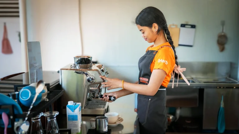 Student with visual impairment preparing coffee at the DYP Inclusive Café and Bakery in Cambodia