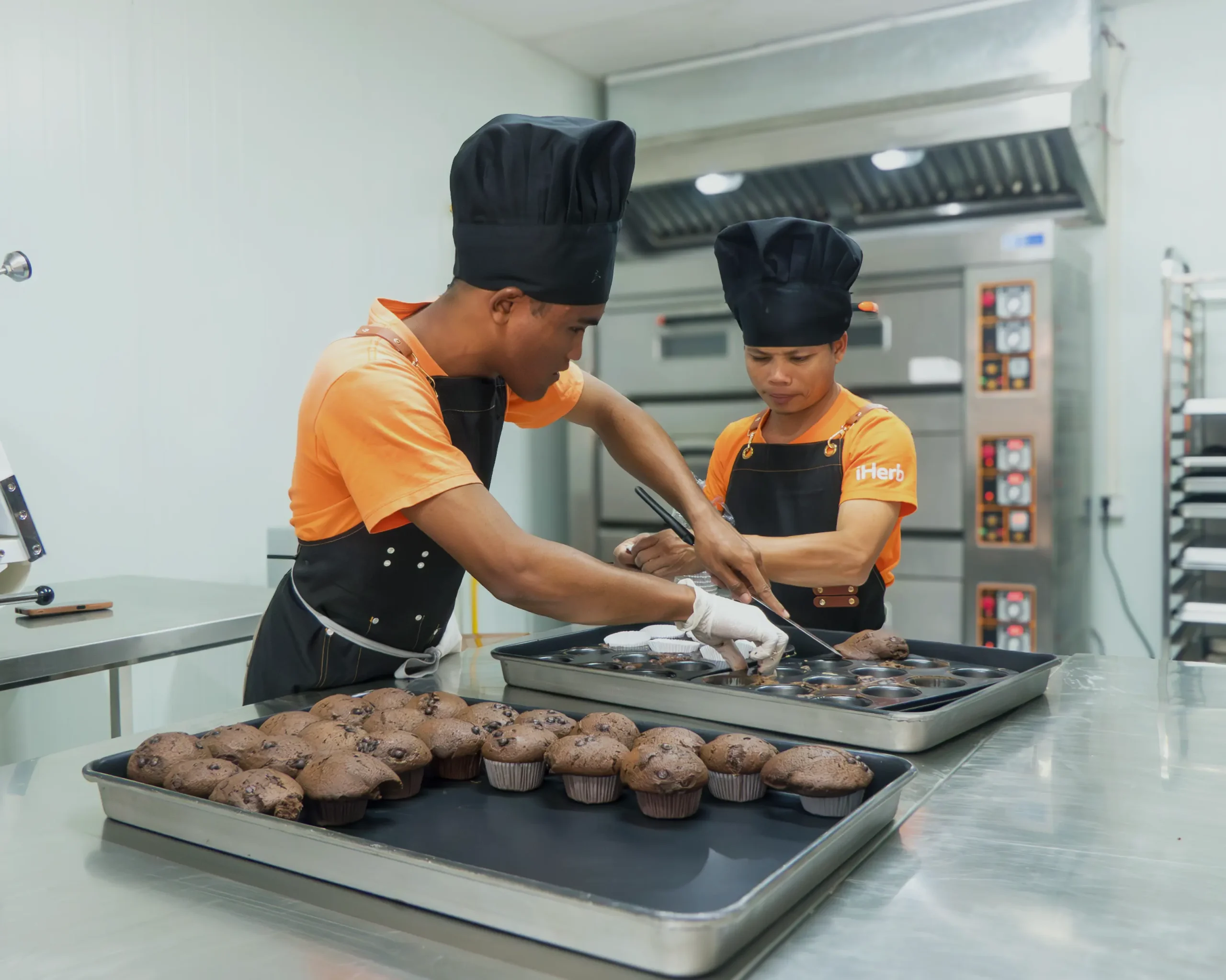 Learners preparing fresh muffins and desserts in a professional kitchen at the DYP Inclusive Café and Bakery in Cambodia