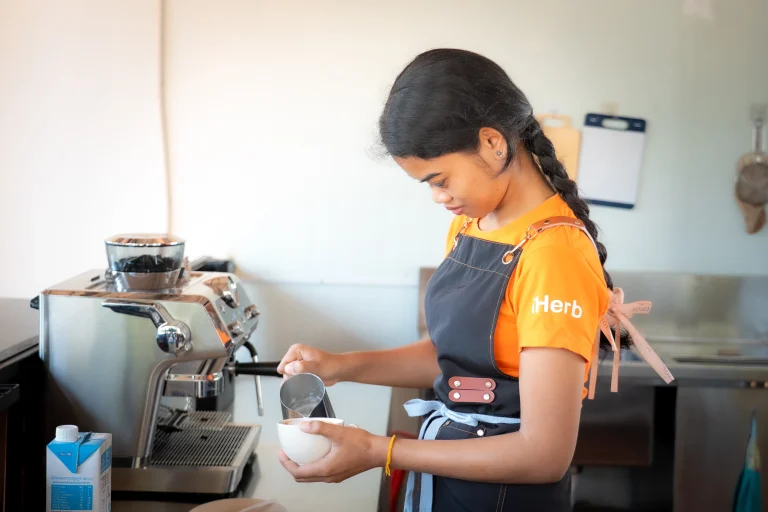 Student with visual impairment preparing coffee during hands-on beverage training at the DYP Learning Center in Cambodia