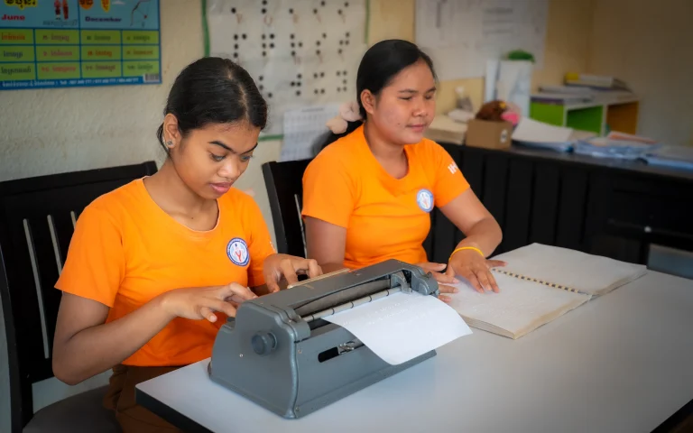 Students with visual impairments learning braille reading and writing using a brailler at the DYP Learning Center in Cambodia