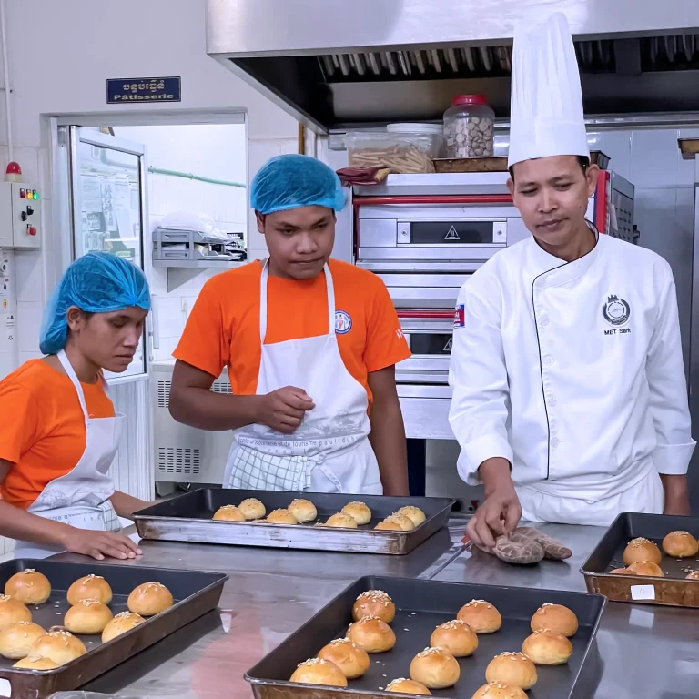 Visually impaired students learning bakery skills with a professional chef during a DYP and EHT hospitality training workshop in Cambodia.