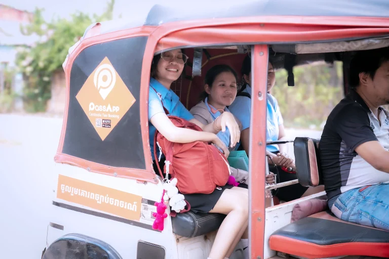 Students traveling by tuk-tuk to attend university classes in Cambodia.