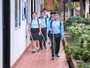 Students with visual impairments walking with white canes on campus during their university studies.