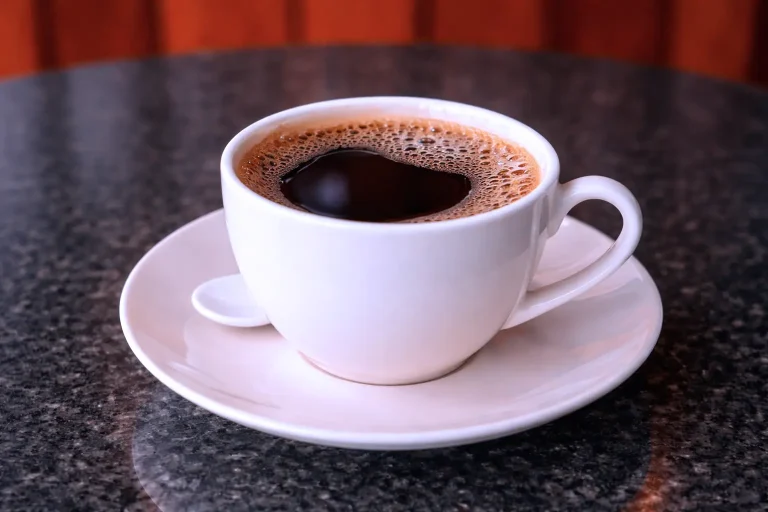 Hot Americano coffee served in a white cup at the DYP Inclusive Café in Siem Reap.