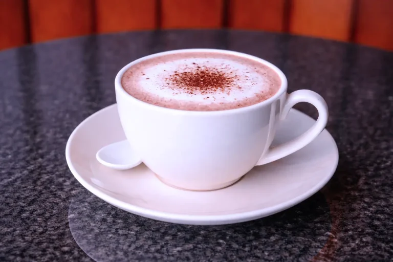 Hot chocolate drink with milk foam served in a white cup at the DYP Inclusive Café in Siem Reap.