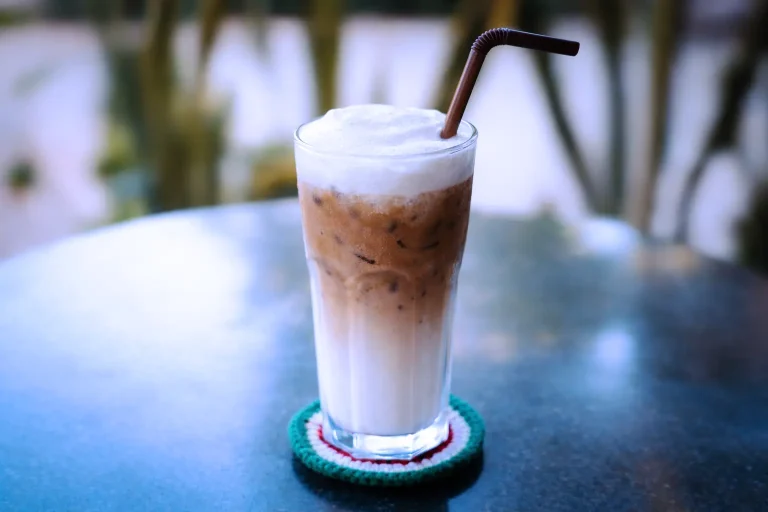 Iced cappuccino with milk foam and espresso served in a tall glass at the DYP Inclusive Café in Siem Reap.