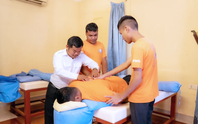 Visually impaired students practicing therapeutic massage training at the DYP Learning Center in Cambodia.