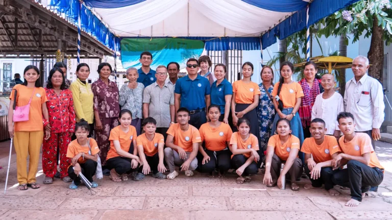 Discover Your Possibilities (DYP) team with community members in Cambodia supporting people with visual impairments