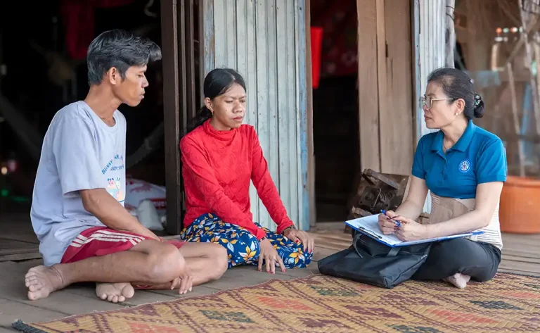 DYP staff providing food support to a visually impaired beneficiary in Cambodia