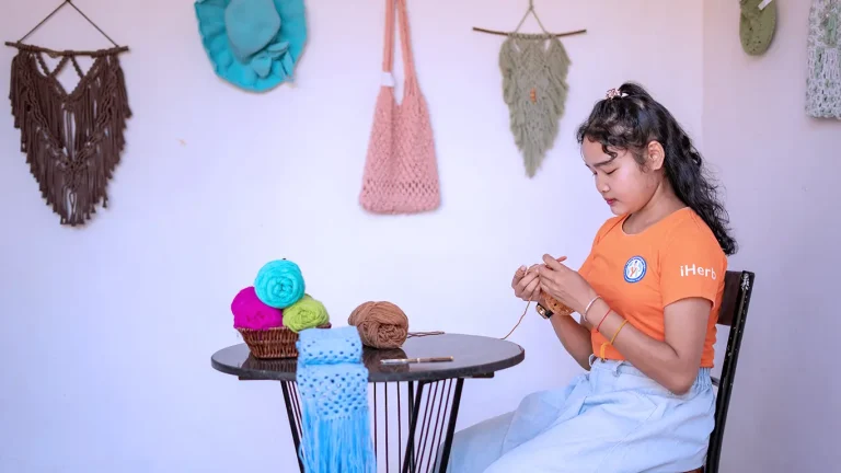 Student with visual impairment creating handmade crochet crafts at the DYP Learning Center in Cambodia.