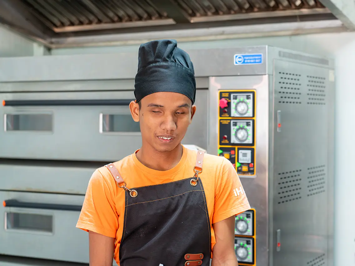 Mek wearing a baker’s uniform during bakery training at DYP Cambodia