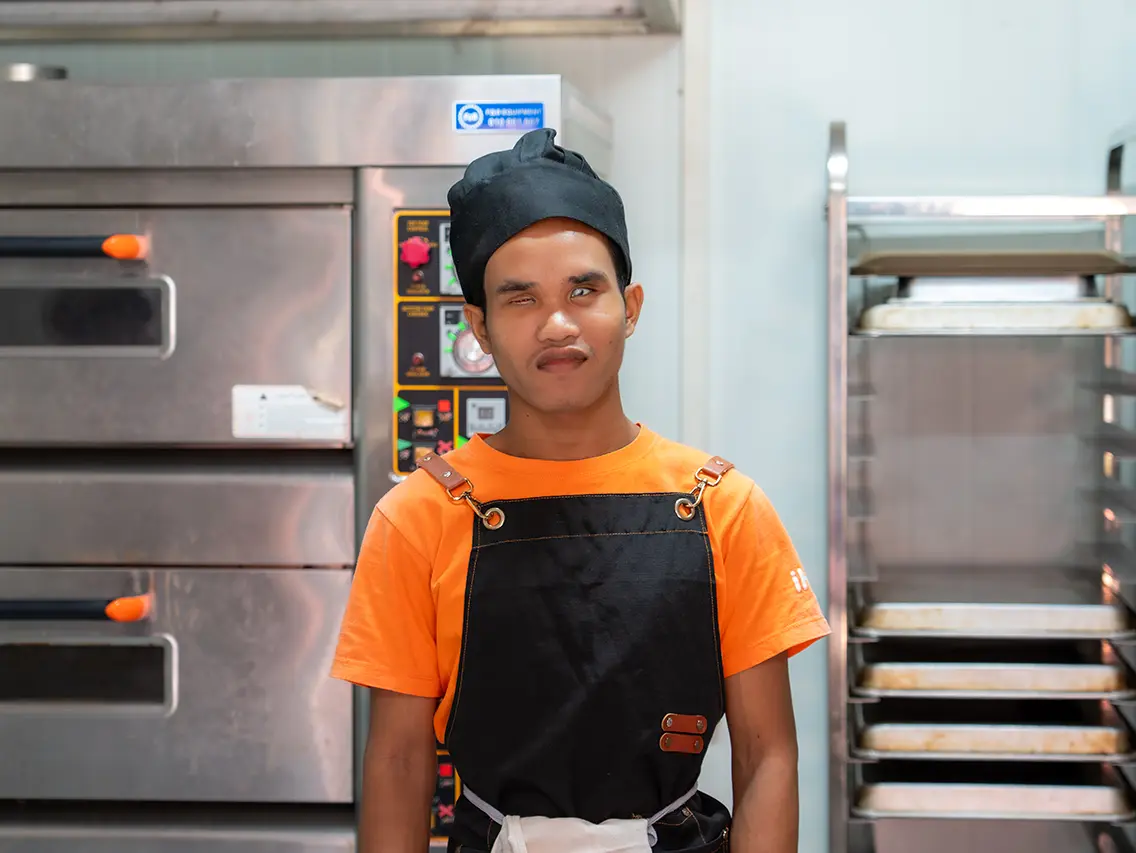 Pich wearing a baker’s uniform during bakery training at DYP Cambodia