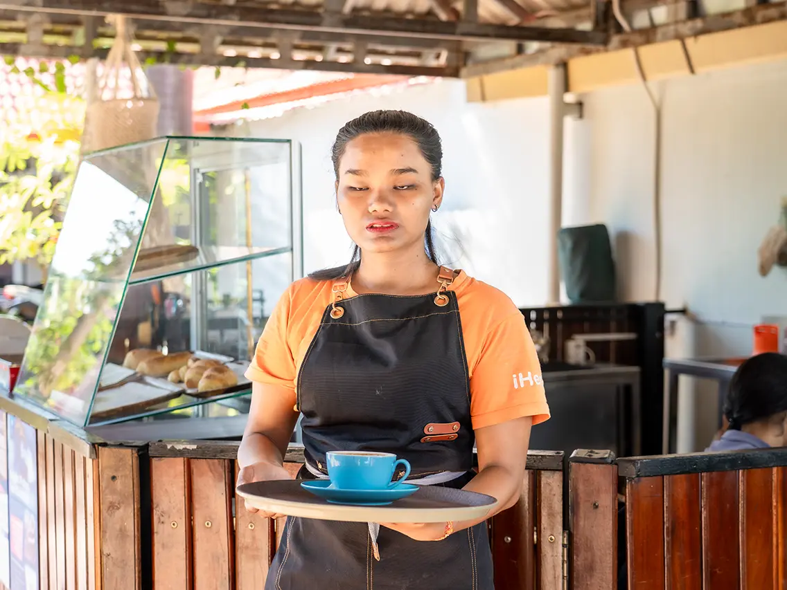 Reaksa serving a cup during barista training at DYP Cambodia