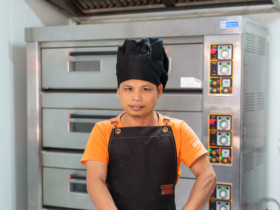 Se wearing a baker’s uniform during bakery training at DYP Cambodia