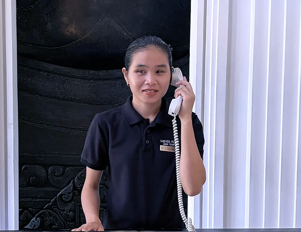 Sreynet practising telephone communication during front desk training