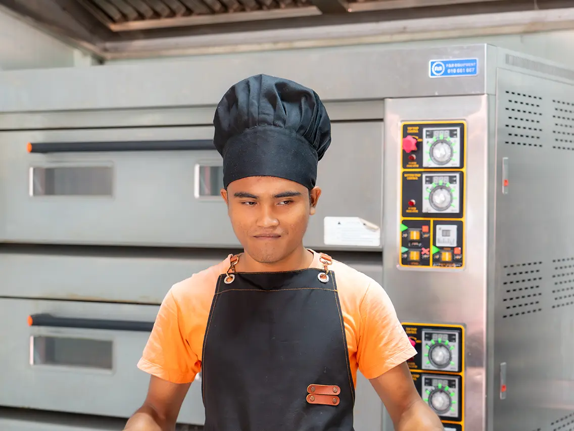 Ya wearing a baker’s uniform during bakery training at DYP Cambodia