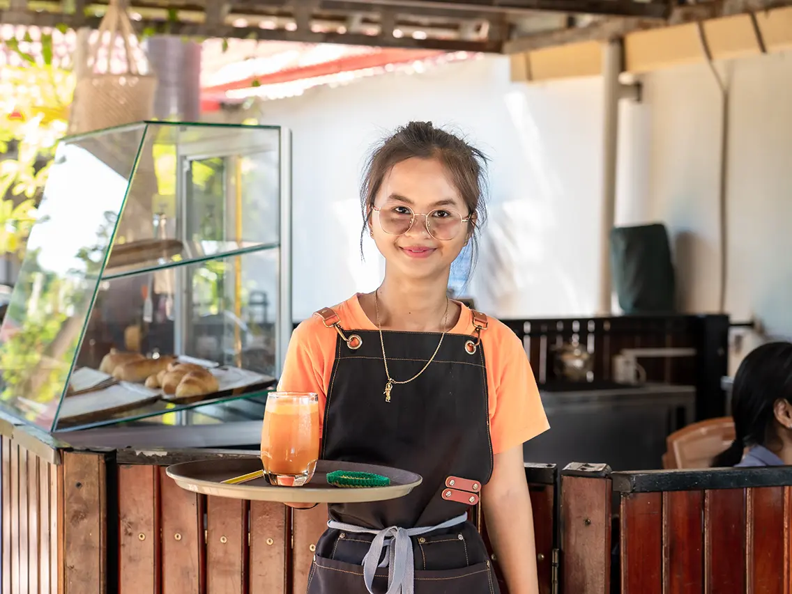 Youn serving a beverage during café training at DYP Cambodia